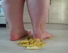 a big mature woman, bbw, smash a banana with bare feet, heels. crash trampl
