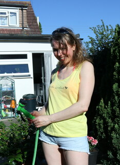 Hairy mature lady playing with the hose in the garden